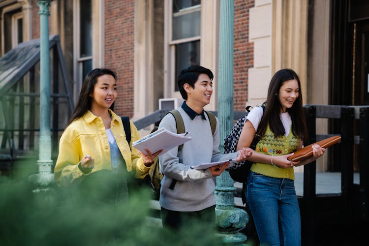 Photo Of A Man And His Friends Talking While Walking