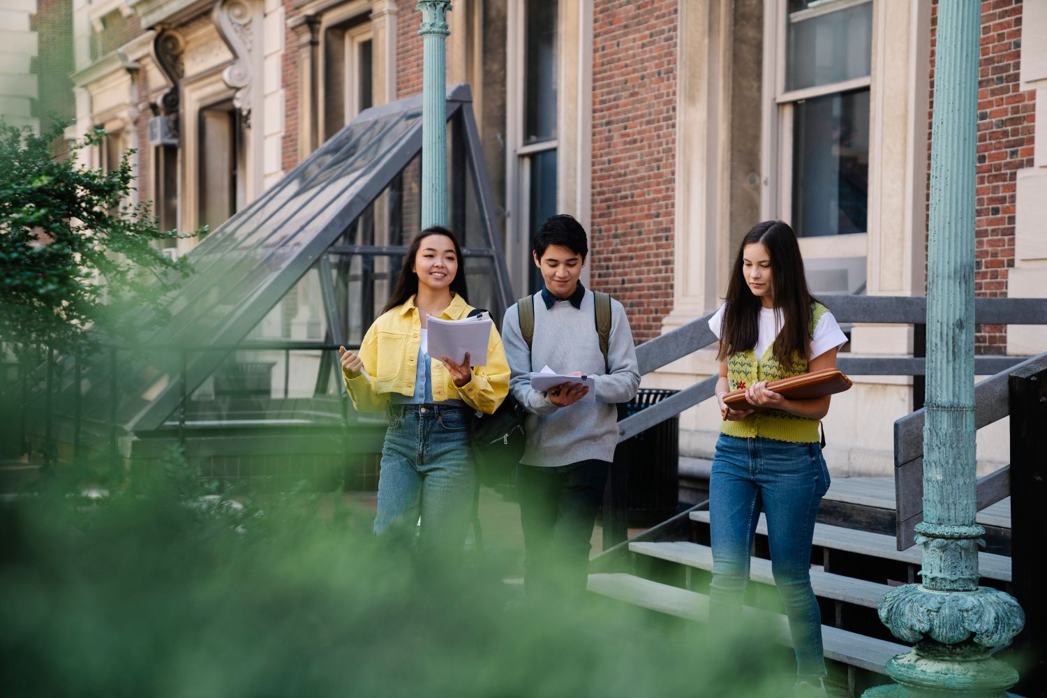 A diverse group of teenage students walking and talking on a university campus