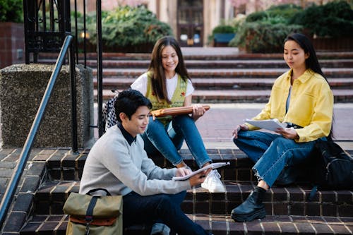 Photograph of a Group of Friends Sitting on Brick Steps