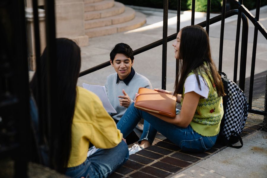 Students sitting together outdoors on campus discussing their academic plans