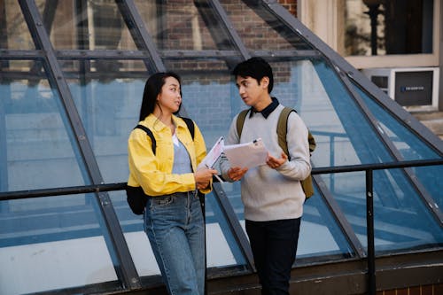 Man Holding Papers While Talking to a Woman