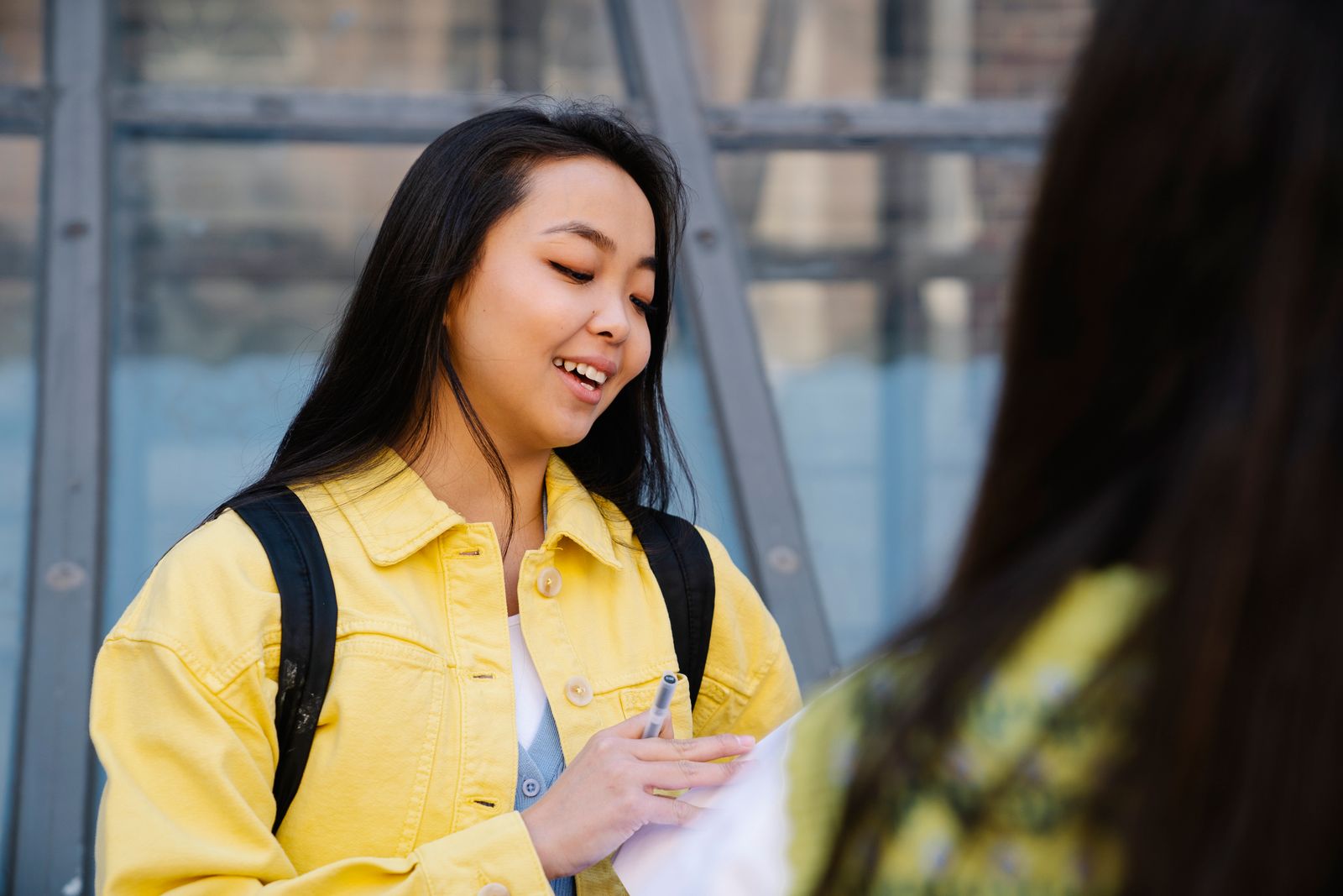 Smiling young woman in a yellow jacket