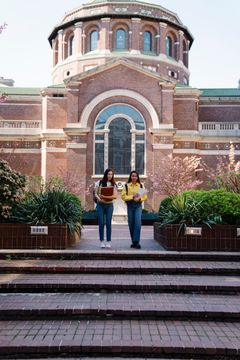 Students walking past a university building, photo by George Pak on Pexels