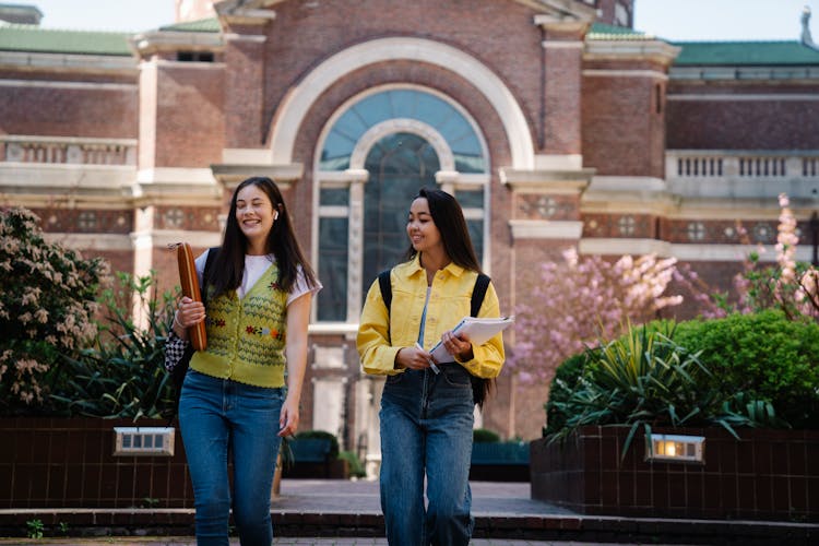 College Girl Walking With Their Notes And Smiling 