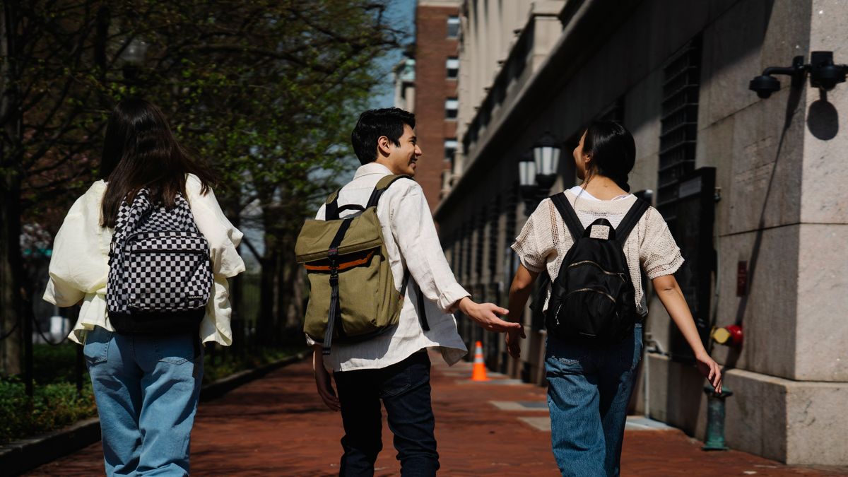リュックを背負ってキャンパスを歩く学生たち