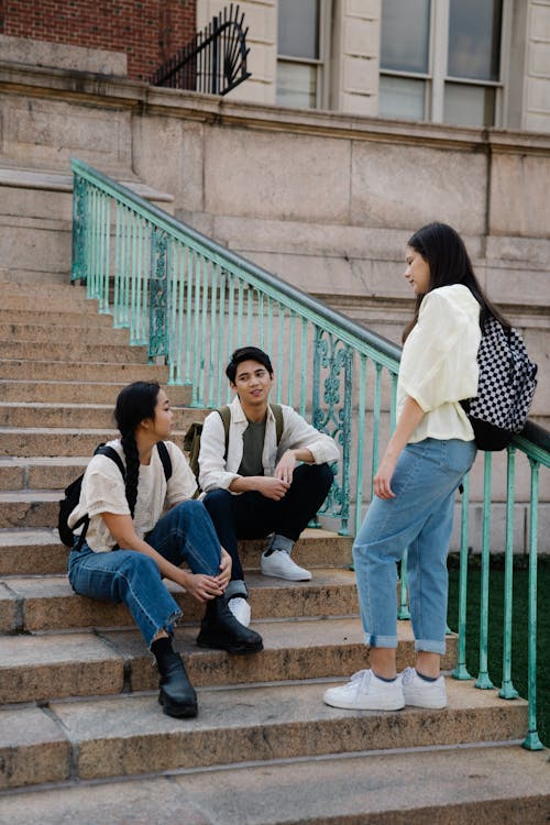 Photo of a Group of Friends Having a Conversation on Concrete Stairs