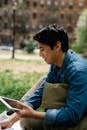 Man in Blue Denim Shirt Holding a Tablet