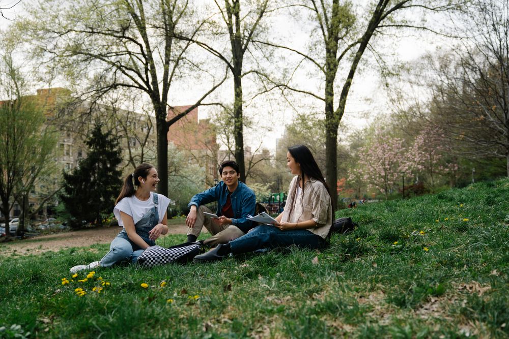 College friends chatting together on the grass