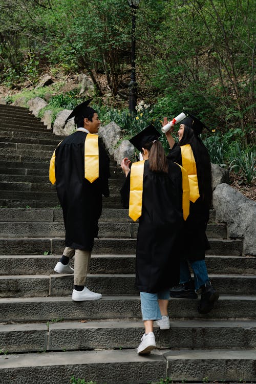 Students Wearing Graduation Gowns Climbing Concrete stairs