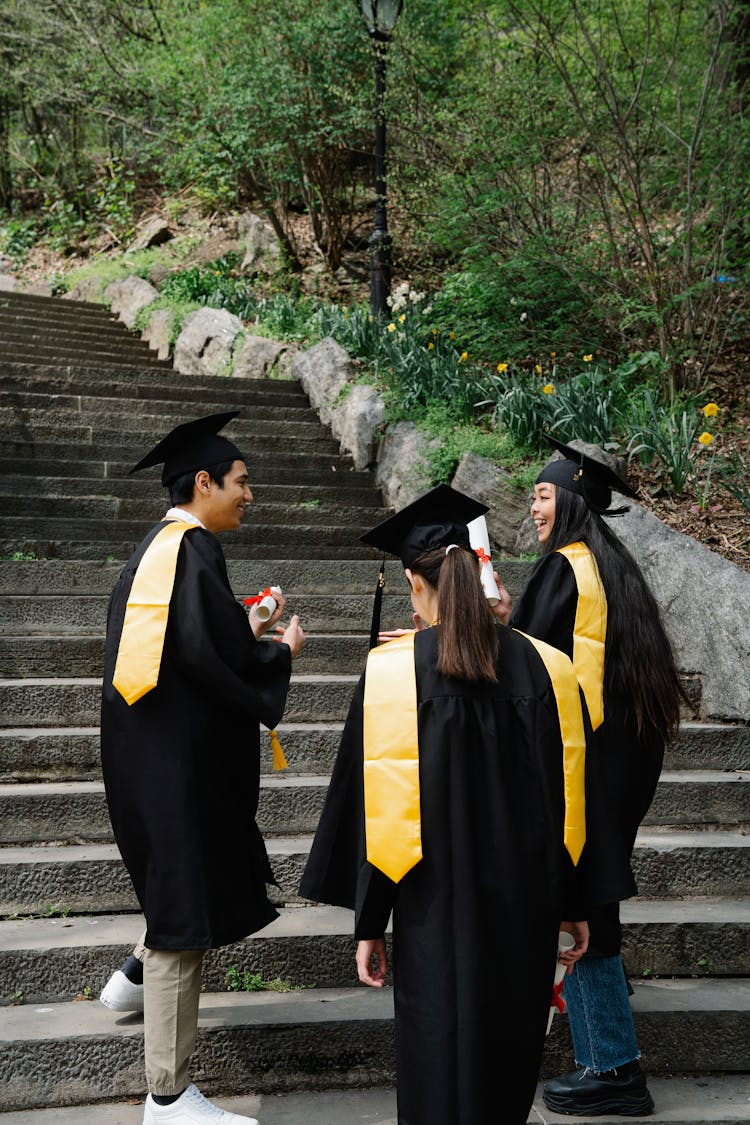 Students N Graduation Caps And Gowns On Stairs