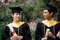 Photo of a Man and a Woman Holding Their Diplomas
