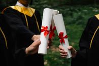 Photograph of People's Hands Holding White Diplomas
