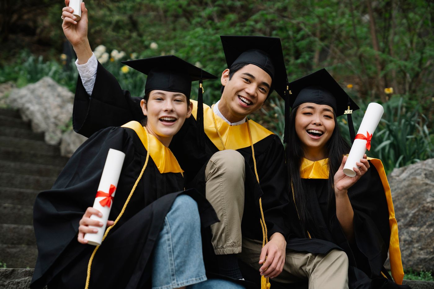 Smiling graduates holding their diplomas