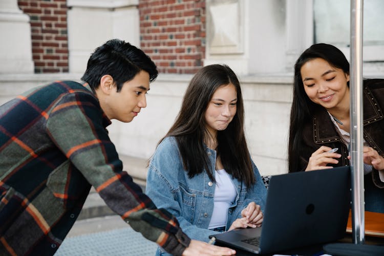 Students Studying On Laptop Outdoors Together