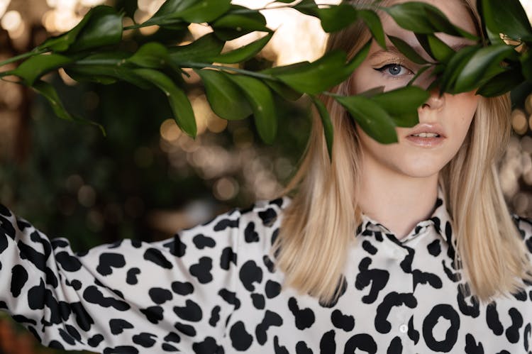 Woman In Leopard Print Long Sleeve Shirt With Green Leaves Covering Her Eye