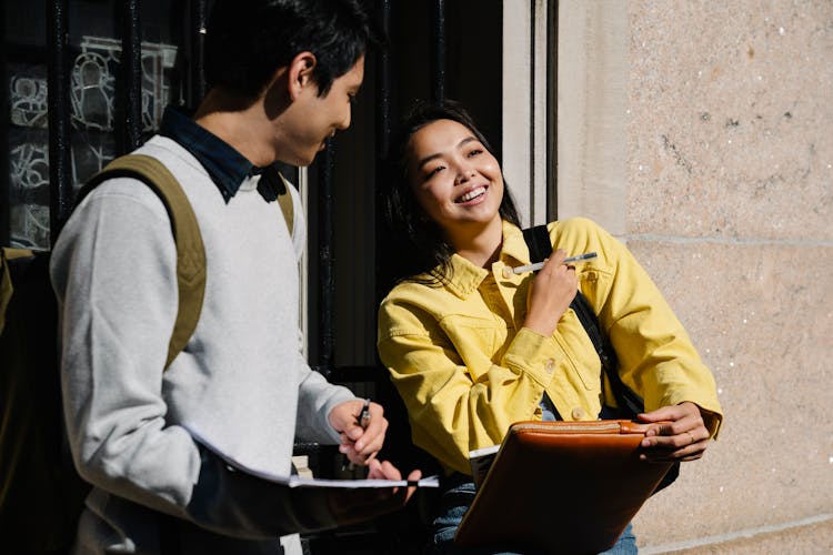 College Students Standing Talking And Smiling 