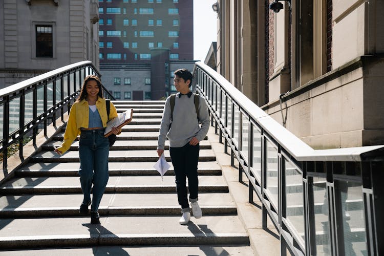 Two Students Talking While Walking Down An Outdoor Steps