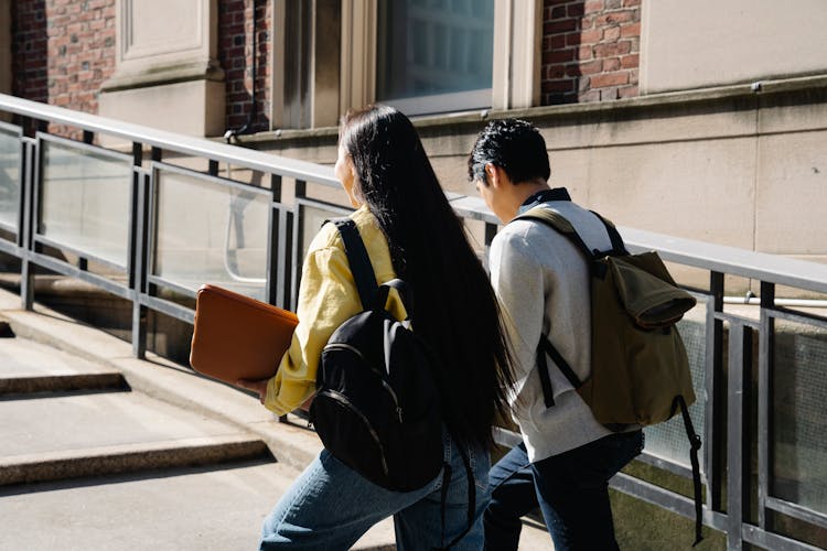 A Man And A Woman Walking Up The Stairs