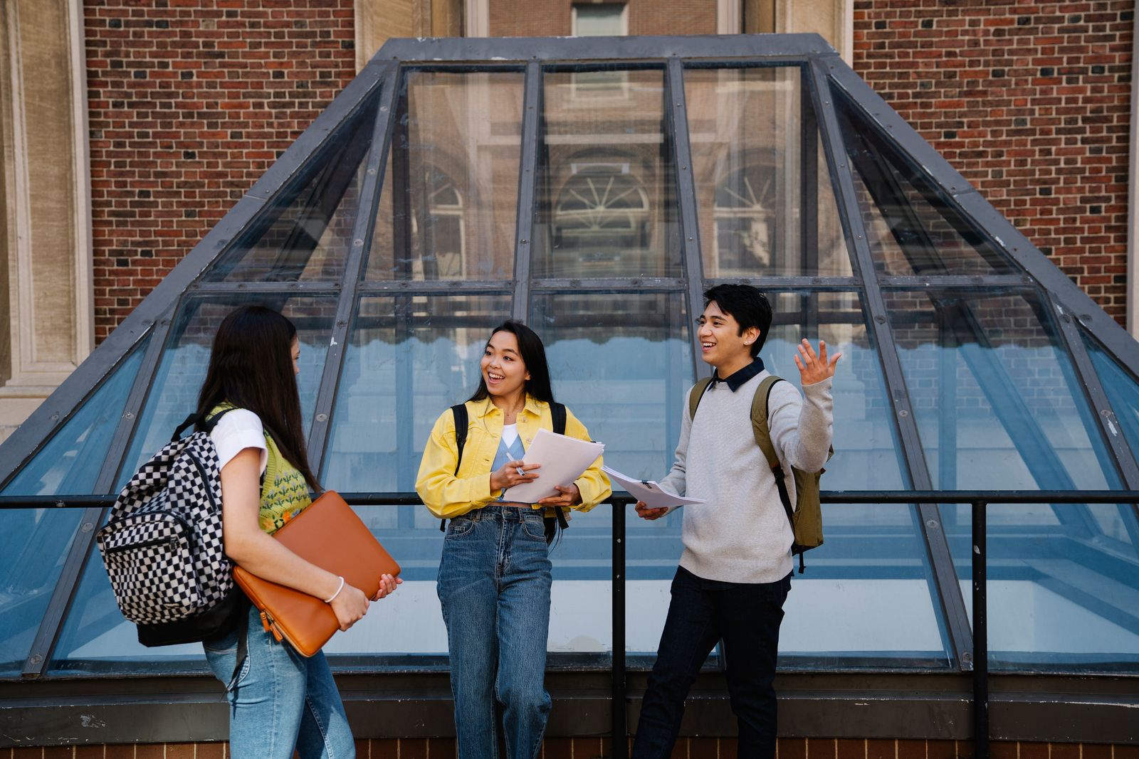 Multicultural students talking together near a modern university building