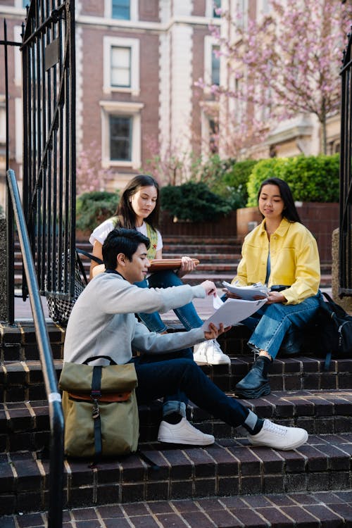 University Students Sitting on Steps and Studying