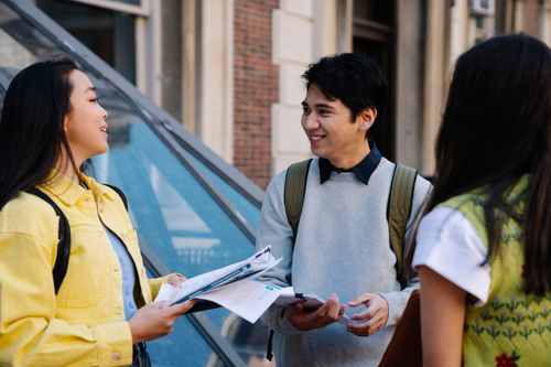 Free Happy group of university students discussing outdoors with books and papers. Stock Photo