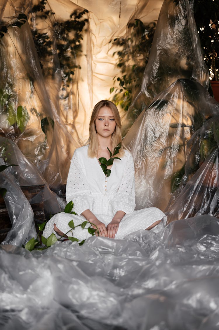 A Woman In White Outfit Sitting On Transparent Plastic 