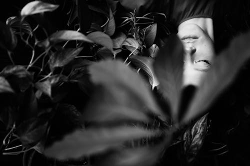 Grayscale Photo of Woman Surrounded with Plants