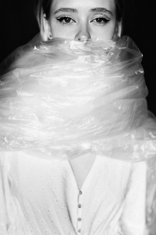 Black and Whit Photo of a Woman with a Plastic Film Wrapped Around her Neck 