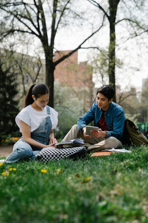 Young Couple Sitting in Park and Studying · Free Stock Photo
