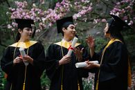 Woman in Black Academic Dress Holding White Printer Paper