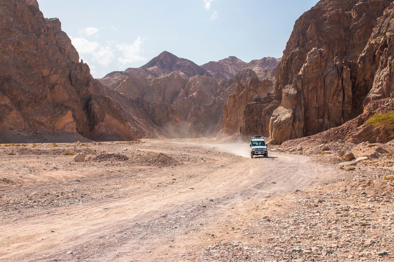 4x4 truck with 4WD low range driving through a rocky desert canyon trail