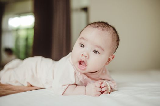 Cute baby lying on bed, looking curiously. Perfect for family and lifestyle themes.