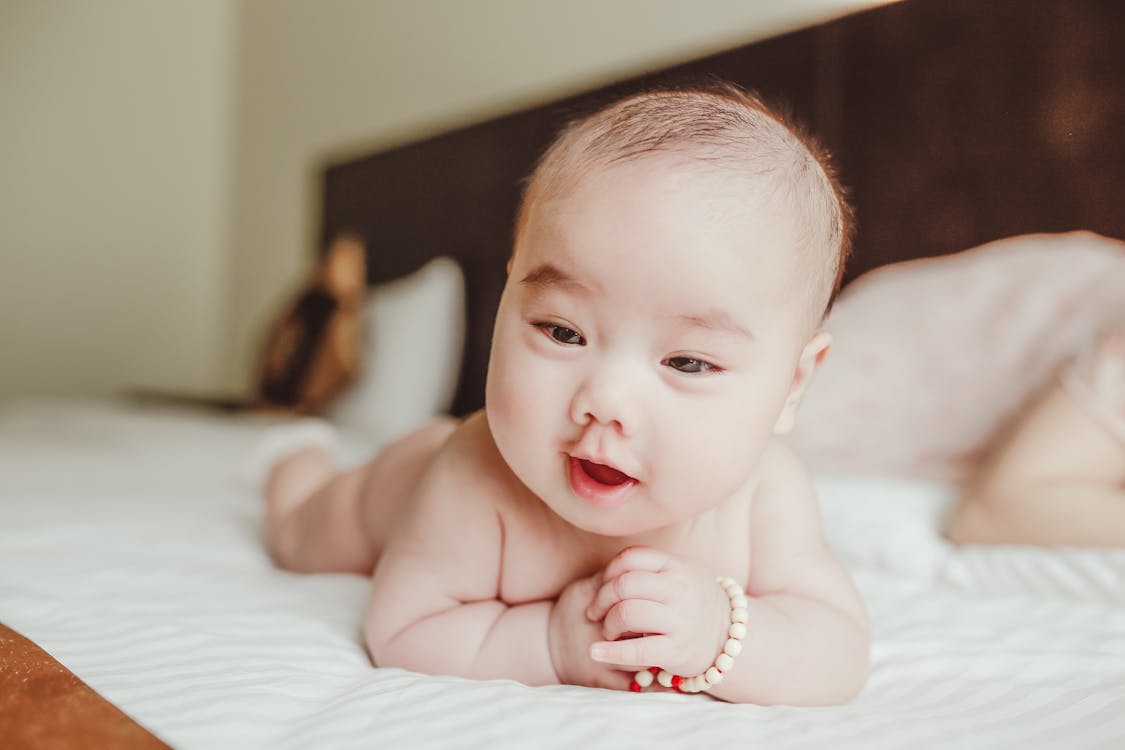 Topless Baby Lying on Bed · Free Stock Photo