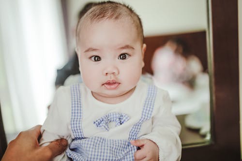 Free Cute newborn baby in blue and white bodysuit Stock Photo