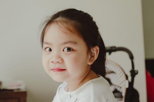 Charming little girl with plant at home · Free Stock Photo