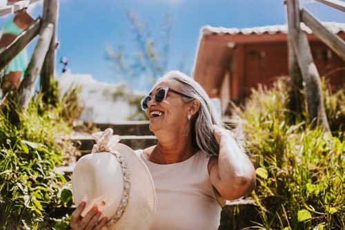 Free Happy senior woman with sunglasses and sunhat smiling outdoors on a sunny day. Stock Photo