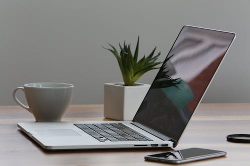 Silberner Laptop Und Weiße Tasse Auf Dem Tisch