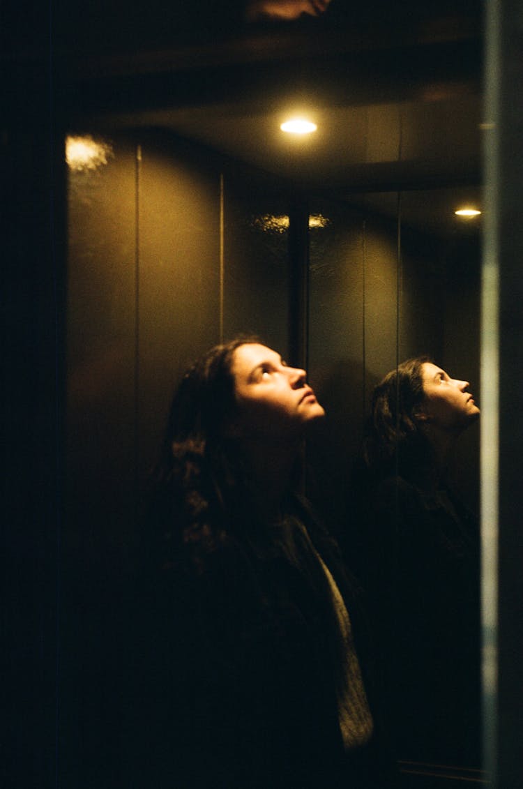 Photo Of A Woman In An Elevator Looking At The Light