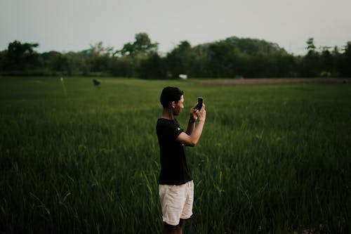 Free Man Standing on Grassfield Stock Photo