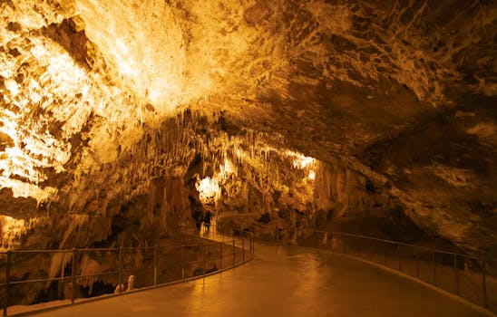 Explore the stunning formations of Postojna Cave in Slovenia, showcasing dramatic stalactites and lighting.