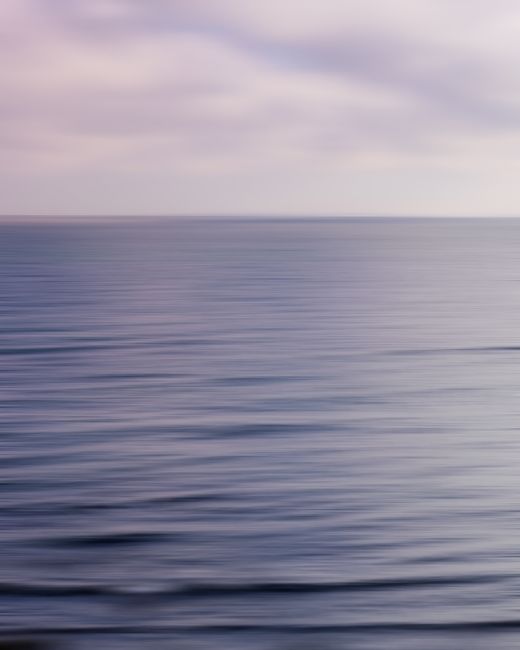 A tranquil view of the Baltic Sea with soft pastel hues at sunset, capturing peaceful ocean waves and an endless horizon.