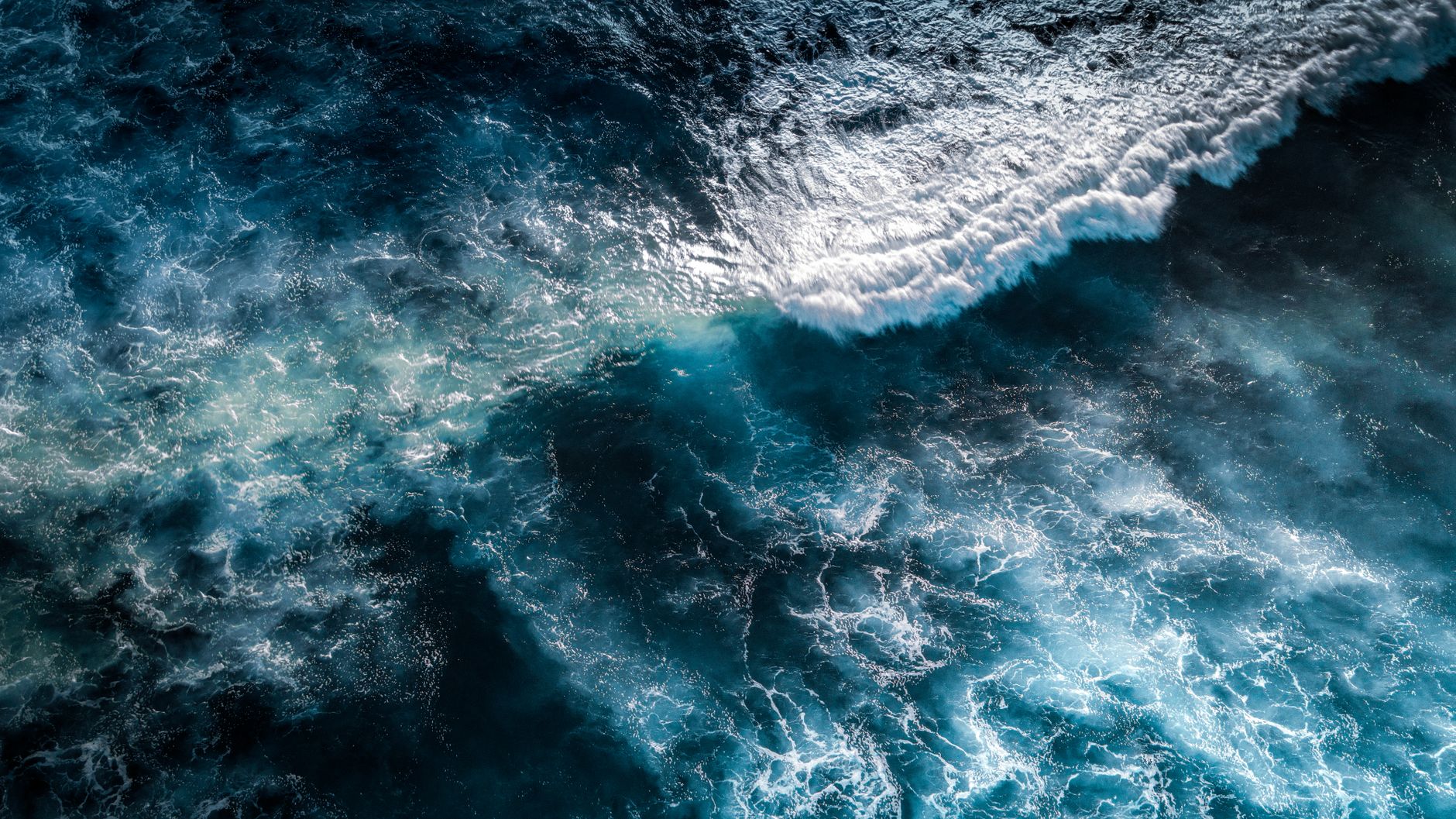 Aerial view of ocean waves and white foam