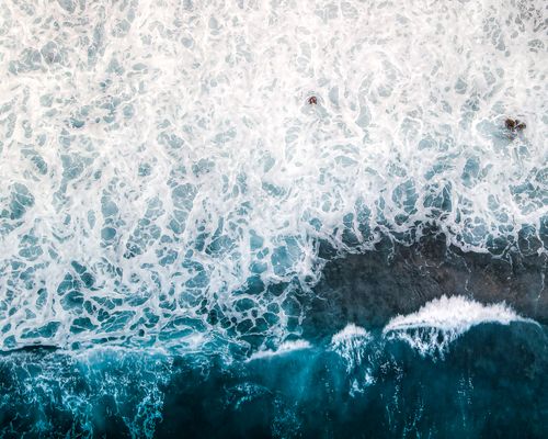 Free Aerial photograph capturing the dynamic motion of white ocean waves crashing on the shore at Saint-Benoît, Réunion. Stock Photo