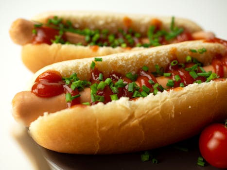 Mouthwatering hotdogs topped with ketchup and fresh chives, perfect for snack time.