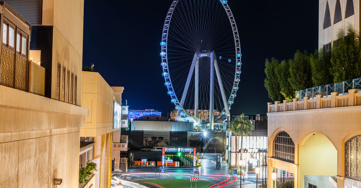 Dubai Ferris Wheel and cityscape beautifully illuminated at night, showcasing urban energy.