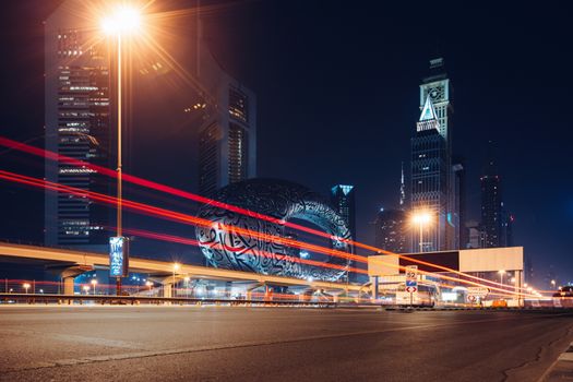 Stunning long exposure photo capturing the dynamic night lights and architecture of downtown Dubai, featuring the iconic Museum of the Future.