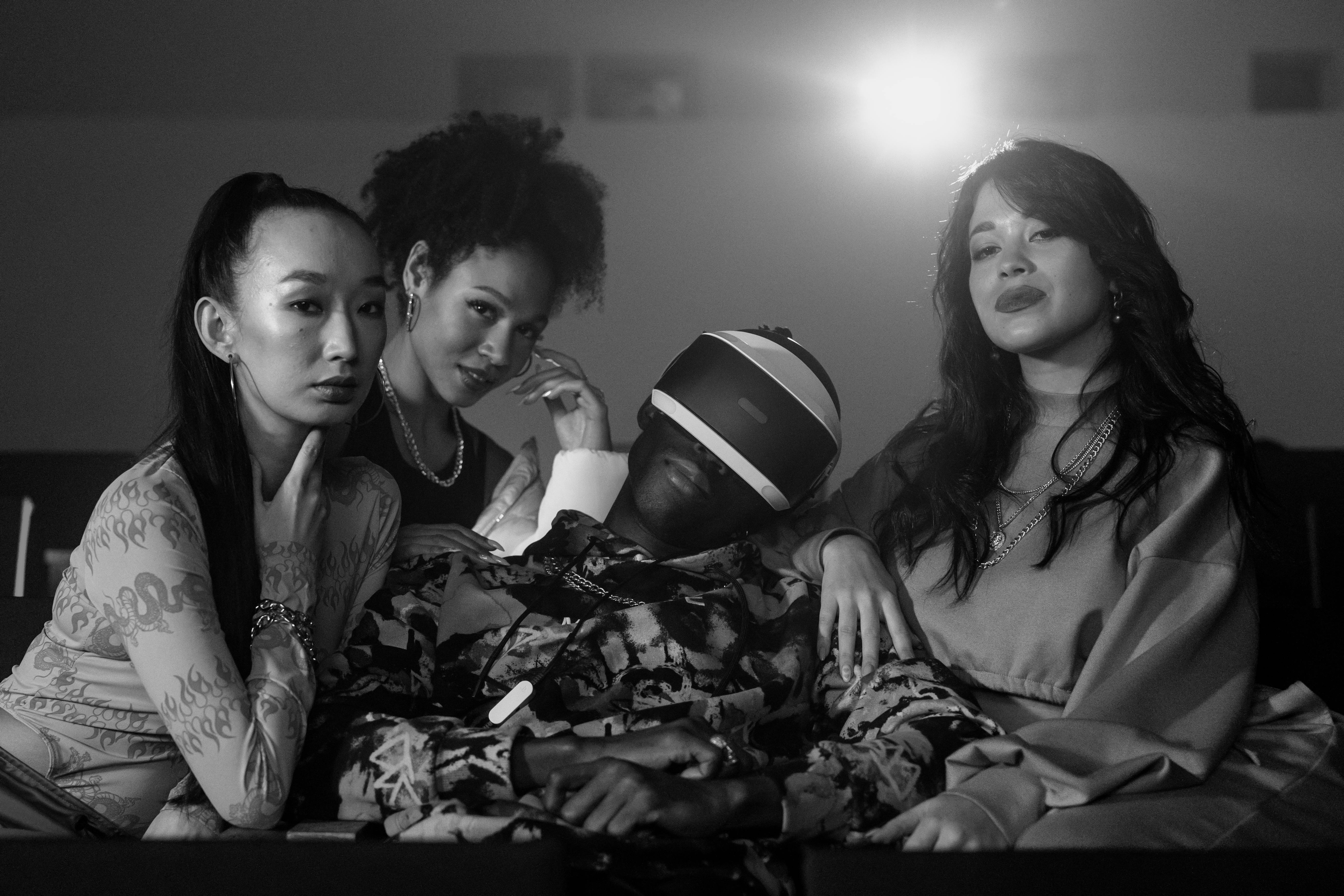 grayscale photo of women sitting beside a man wearing vr goggles