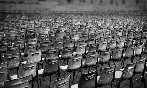 Grayscale Photo of Chairs in the Stadium