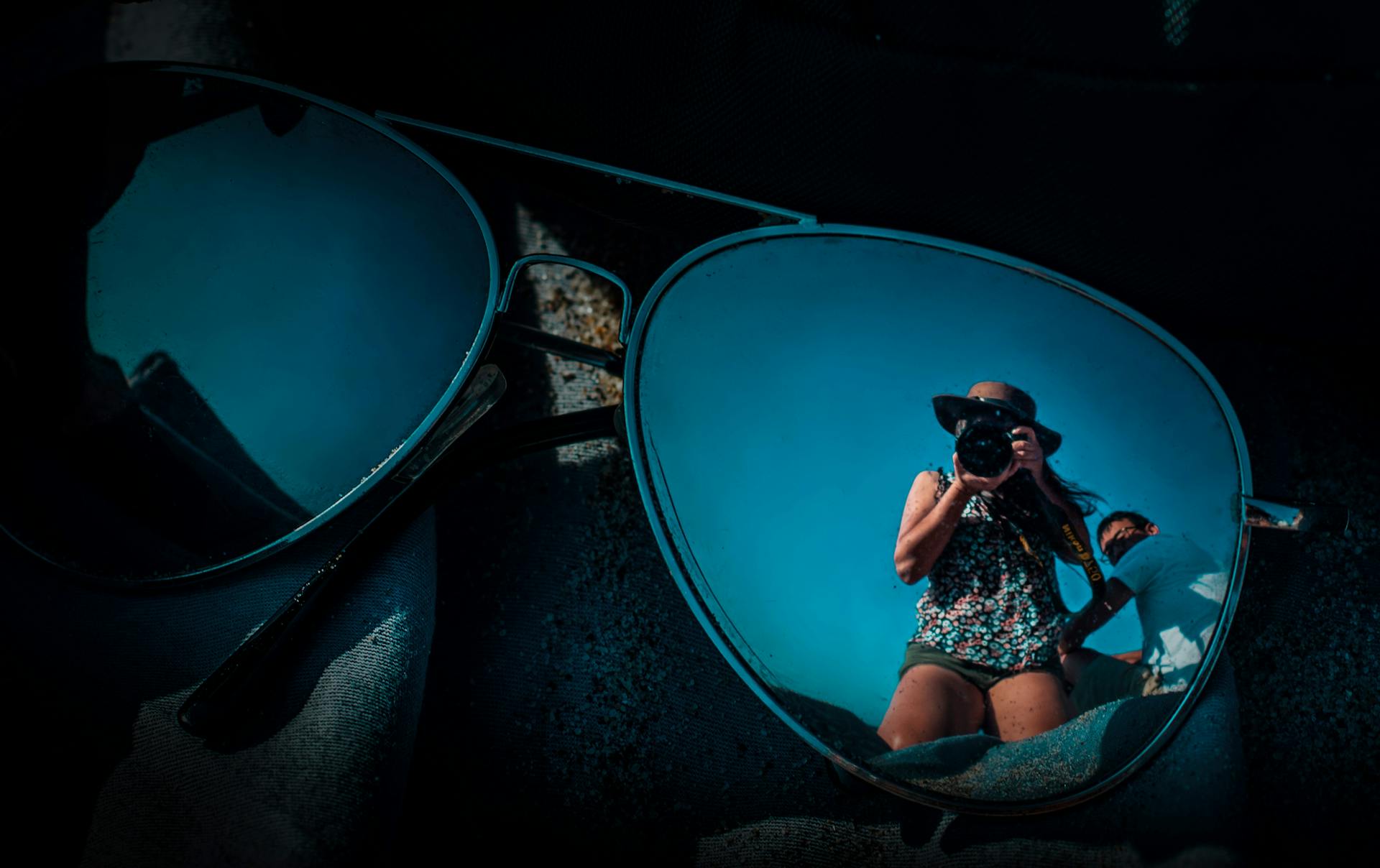 Unique reflection photo capturing a photographer through sunglasses. Vibrant and artistic concept.