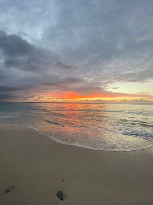 Free Captivating sunset over a tranquil beach and gentle waves, creating a serene seascape. Stock Photo